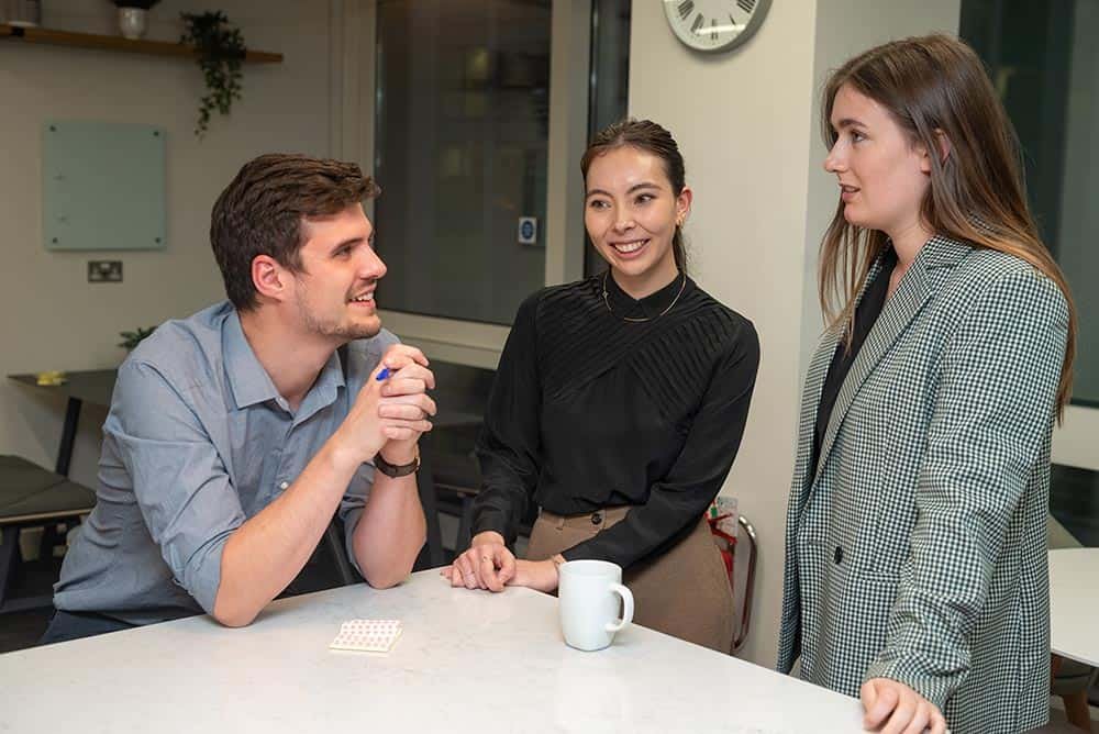 Why Custom Stock Photography Beats Generic Images 13 Brightly lit corporate meeting with colleagues discussing strategies in a modern office.