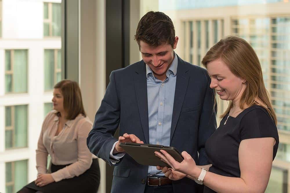 Why Custom Stock Photography Beats Generic Images 3 Professional corporate photographers capturing team moments in a business office environment.