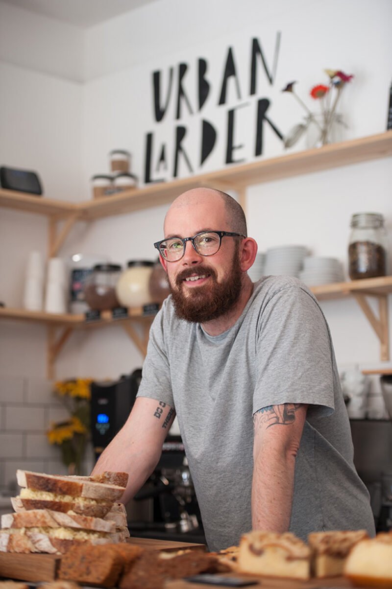 Brand image library photograph of an independent Cambridge shop owner in his shop, by Jean-Luc Benazet.