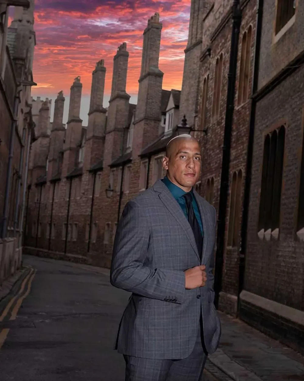 Founder in a grey suit photographed in a Cambridge lane at sunset by Jean-Luc Benazet, branding photographer.