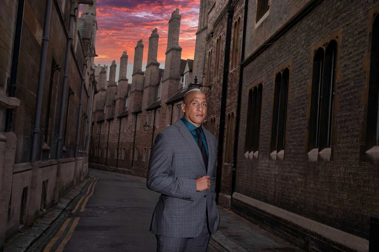 An on-location branding portrait among historic Cambridge buildings beneath a colourful evening sky